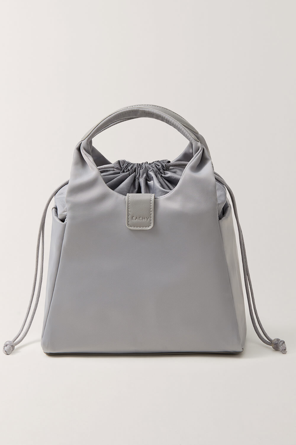Side angle of EACHY grey drawstring cooler bag showing pockets