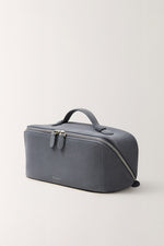 Slate blue cosmetic bag side view, minimalist design with durable handle and double zippers