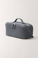 Slate blue cosmetic bag side view, minimalist design with durable handle and double zippers