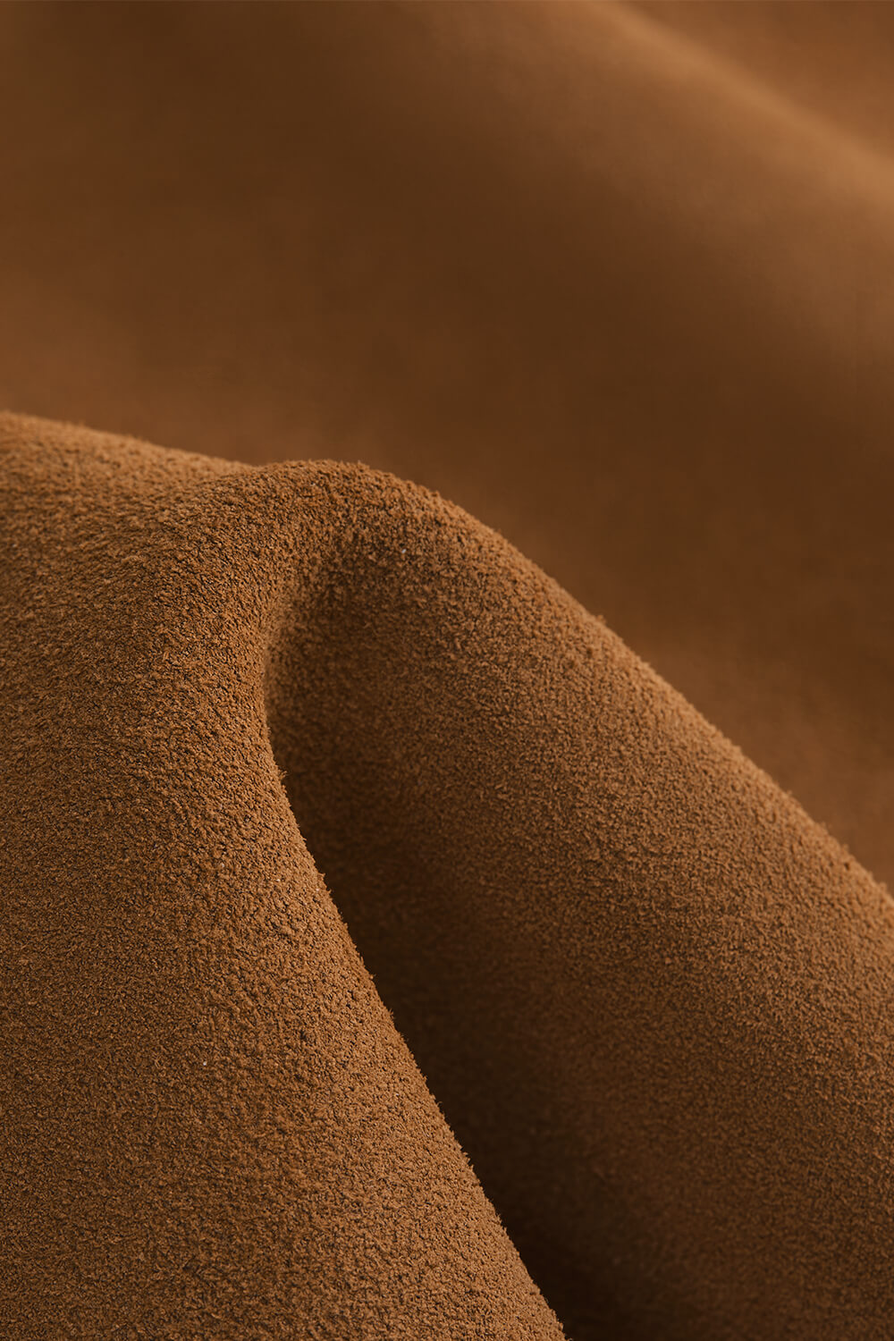 Close-up texture shot of premium soft suede-like brown fabric, durable material detail