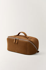 Camel tan cosmetic pouch side view, minimalist design with sturdy handle and zippers