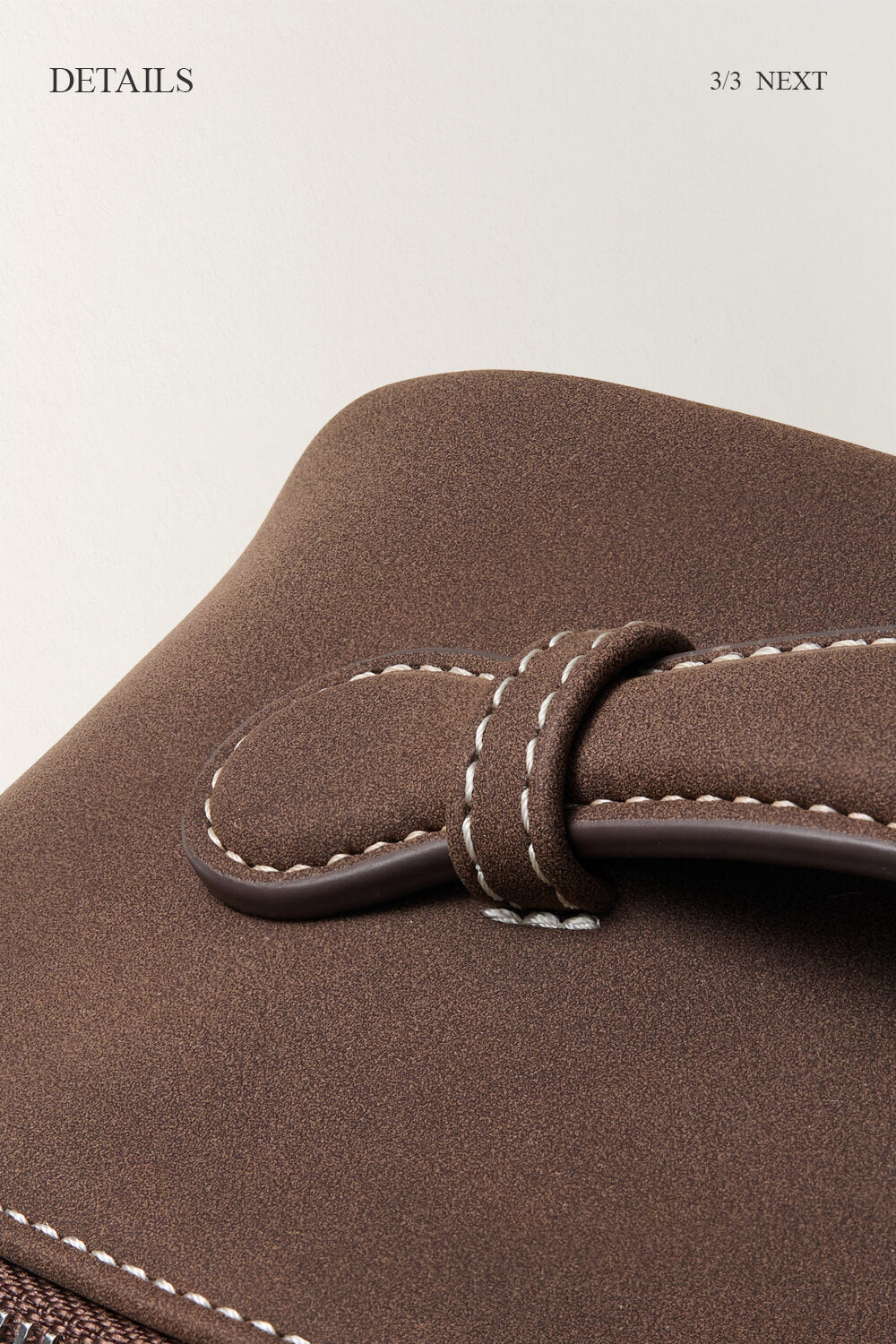 Close-up of black makeup bag handle detail, durable stitching for travel cosmetic bag.