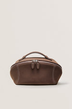 Front view of minimalist black makeup bag for travel, wide-open cosmetic bag.