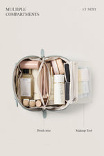 Top view of open blue makeup bag with brushes, spacious travel cosmetic bag capacity.