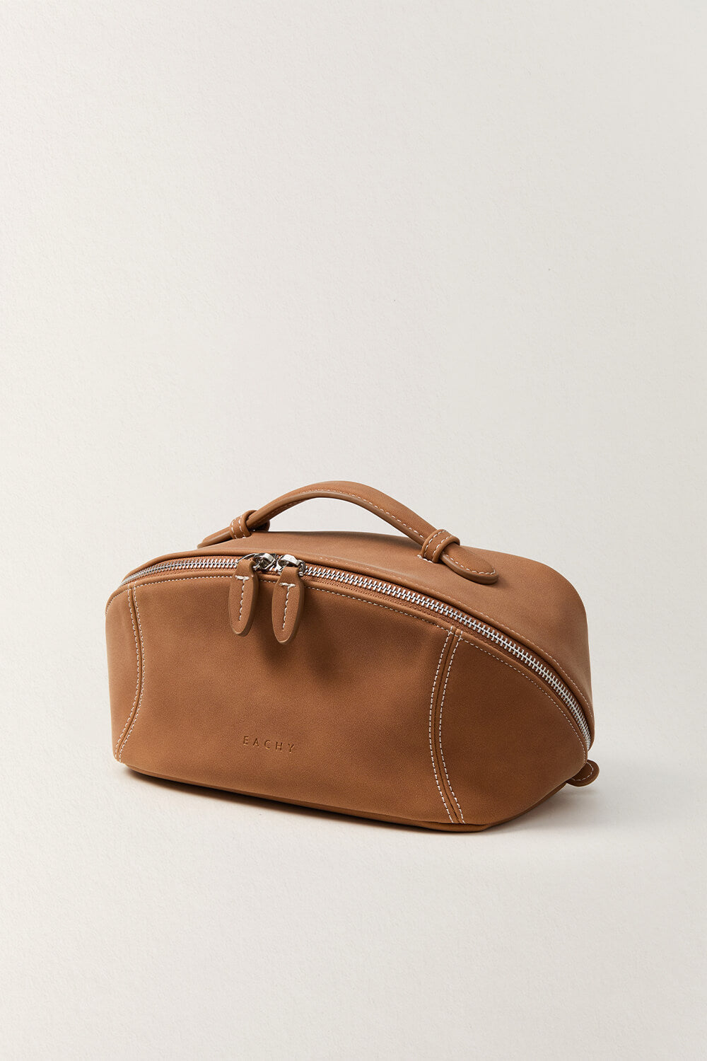 Side view of camel brown makeup bag, soft leather travel toiletry bag.