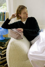 Model holding mauve purple makeup bag, elegant travel cosmetic bag for women.