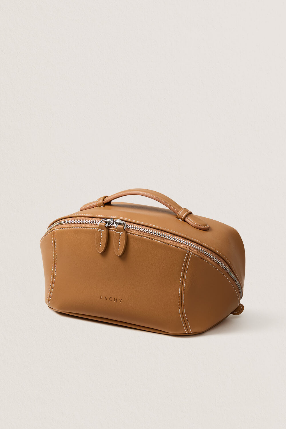 Open view of brown makeup bag showing interior compartments, organized travel toiletry bag.